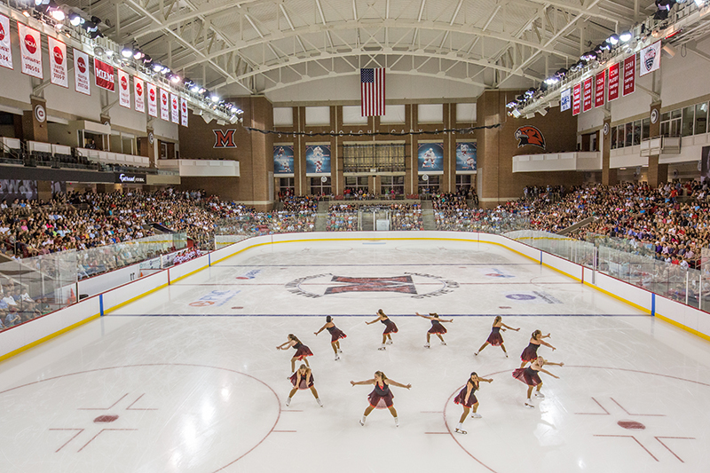 The synchronized skating team skates in a circle during a performance for the first year class at Goggin